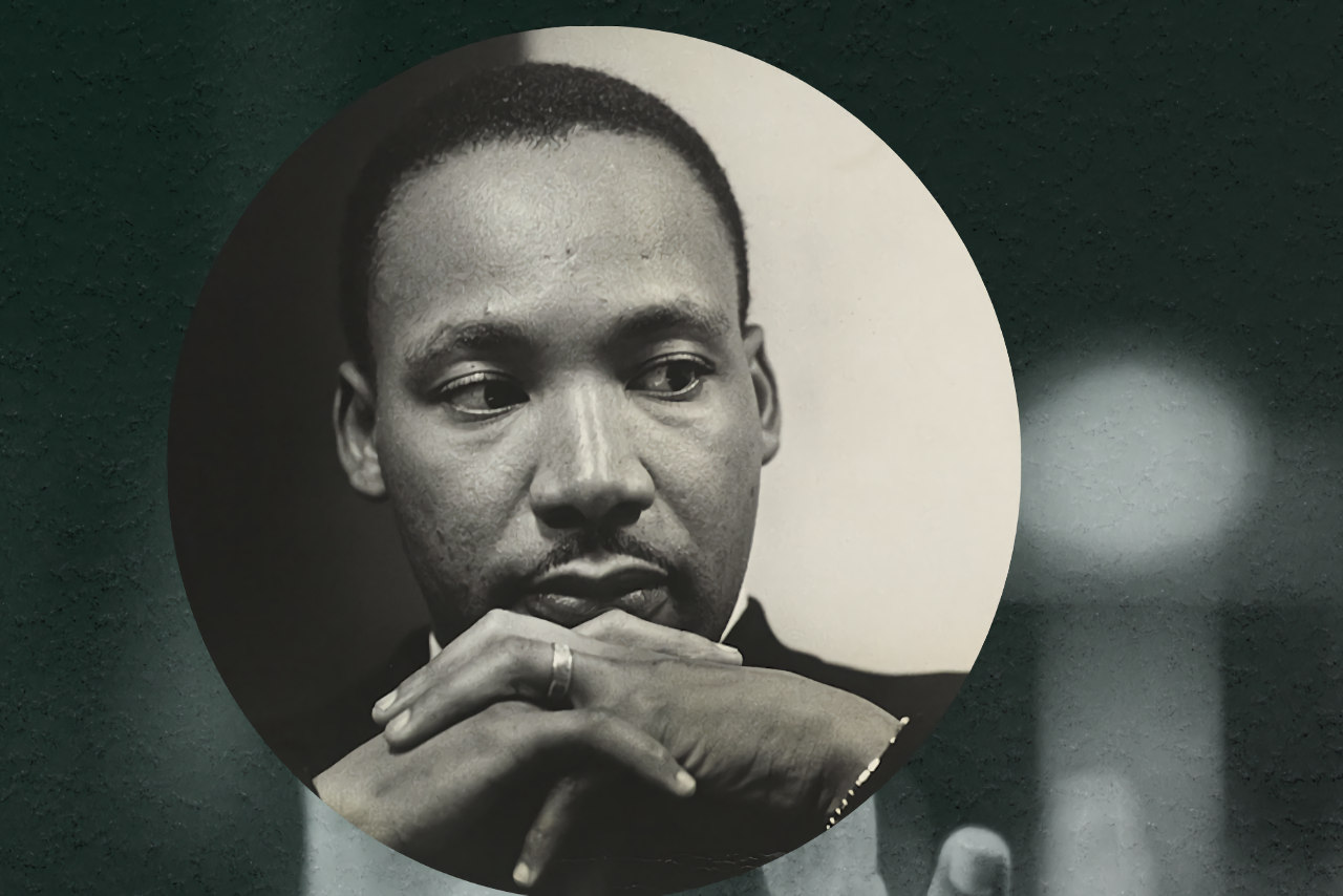 Martin Luther King Junior with his hands clasped in front of him.